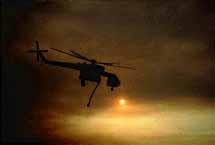 Helicopter water tanker over a smokey sunset